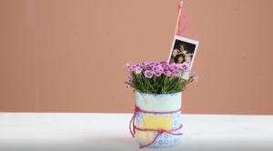 Fretiger Blumentopf aus einer Konservendose mit Foto-Stecker
