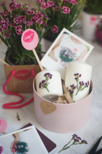 Kerzen mit getrockneten Pink-Kisses-Blüten in einer Geschenkschachtel